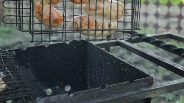 Grill mit hausgemachter Wurst kippt mit Kohlen auf den Grill — Stockvideo