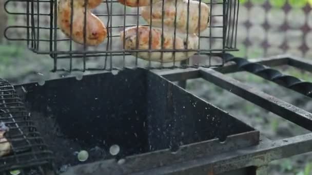 Grill dengan sosis buatan sendiri membalik di panggangan dengan bara — Stok Video