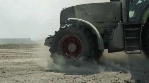 Um trator com uma máquina agrícola processa o solo, muito pó sobe — Vídeo de Stock