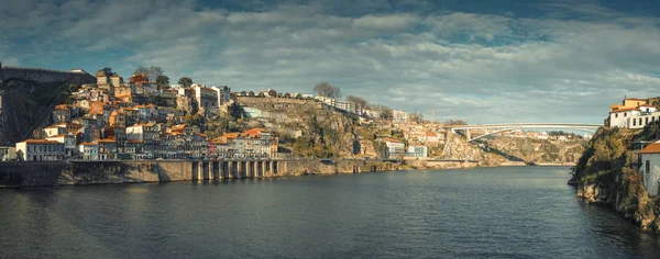 ポルトガルのポルト市内のドゥロ川のほとりにあるリベイラ地区のケーブルカーの隣の丘の上に古い漁村とパノラマ — ストック写真