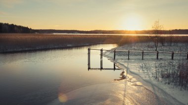 Kuzeyde ilkbaharın başlarında, şafak vakti, bir gölün üzerinde bir tekne iskelesi. Ladoga, Karelia, Rusya