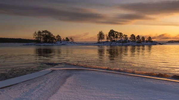 silhouettes of islands and trees on the winter Lake Ladoga in Karelia Russia at sunrise