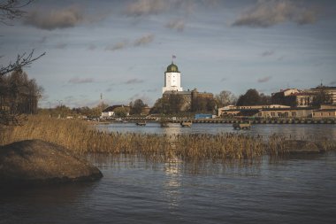 Adadaki Vyborg şatosunun Aziz Olav Kulesi güneşli bir sonbahar gününde Finlandiya Körfezi 'nin sularına yansımaktadır.