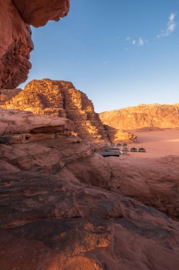 Ürdün 'de Wadi Rum' da bir Bedevi çölünde kum tepeleri ve dağların arasında kamp.