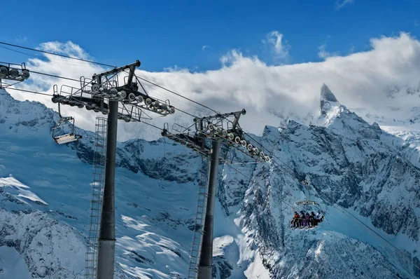 滑雪和滑雪板爱好者提升到滑雪场高在冬季雪山在椅子上缆车 — 图库照片