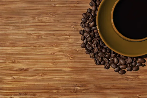 Kopp svart kaffe med bönor på trä bakgrund. Ovanifrån — Stockfoto
