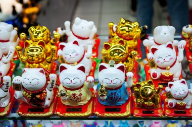 Çince. Japon Hatıra Eşyası. Heykelcik beyaz ve altın kedi iyi şans getirir. Altın Maneki Neko kedi ya da hoş geldiniz maskot