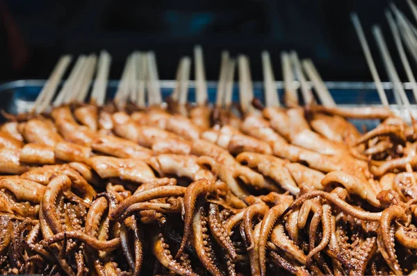 Comida chinesa de rua. Polvo frito sobre pau — Fotografia de Stock