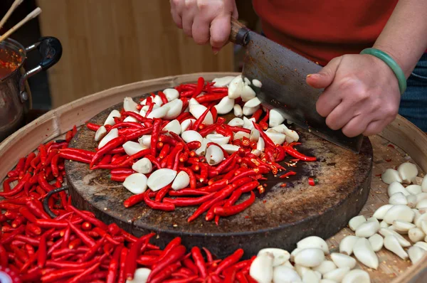 Γυναικεία χέρια κοπή κόκκινες πιπεριές τσίλι και σκόρδο — Φωτογραφία Αρχείου