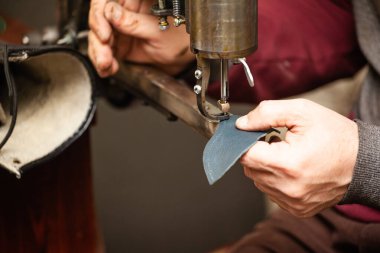 Ayakkabı tamircisinin eline yakın plan bir ayakkabı dikme işi.