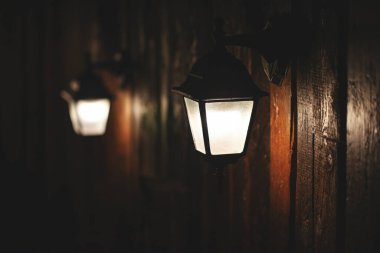 Ahşap bir duvarda eski tarz küçük fenerler, retro tonda.