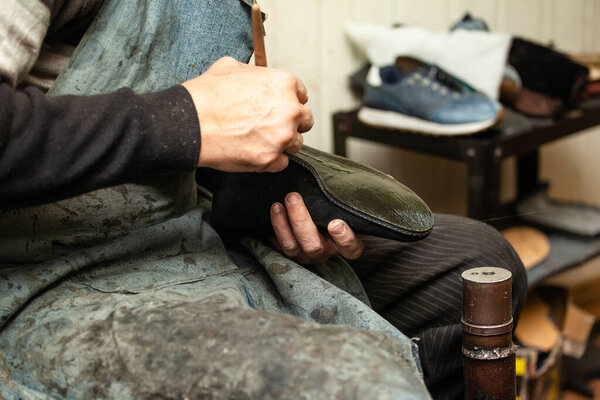 close-up of a male shoemaker's shoe glueing the sole of a shoe
