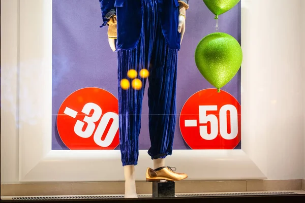 advertising discounts on the shop window with clothes during the sale