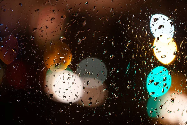 raindrops on the window at night with blurred city lights
