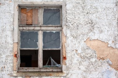 Terk edilmiş bir evin camında kırık cam var.