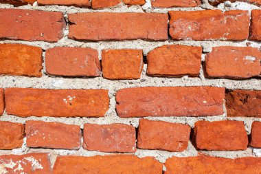 Eski kaba kırmızı tuğlalardan oluşan parlak bir duvar, arka plan, doku