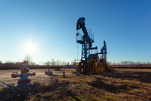 oil production tower while working against the bright sun and blue sky