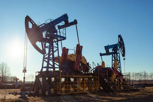 Torre Produzione Petrolio Mentre Lavora Contro Sole Luminoso Cielo Blu — Foto Stock