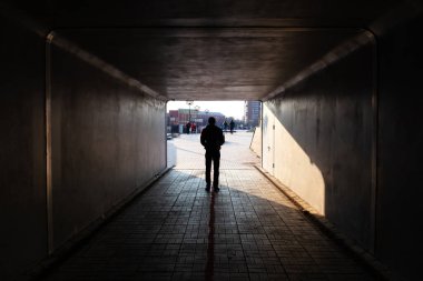 Adam karanlık bir tünelin sonunda duruyor.