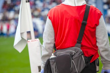 Saha kenarından gelen sporcu doktor maçı izliyor.