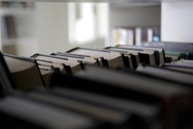 Kitaplıktaki bir rafta yığınla kitap