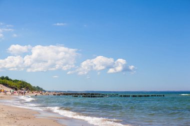 İnsanlar güneşli bir yaz gününde halk plajında güneşlenirler.