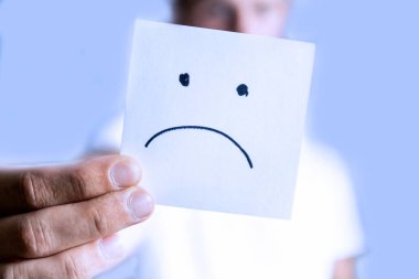 Bir adam uzanmış elinde hüzünlü bir gülümsemeyle bir çarşaf tutar.