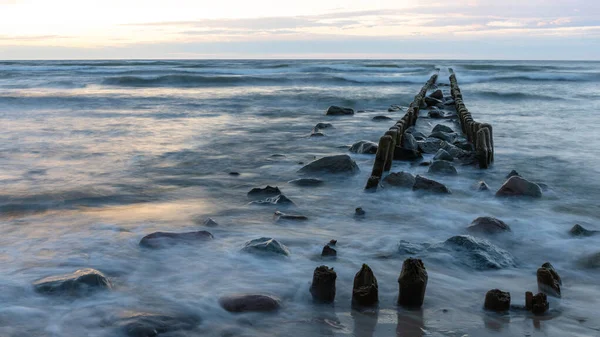 stock image baltic sea with old breakwaters and stones on the coast on a long exposure