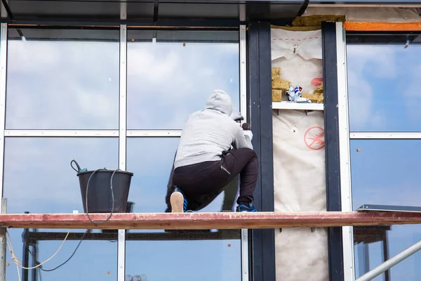 builder installs windows outside the building