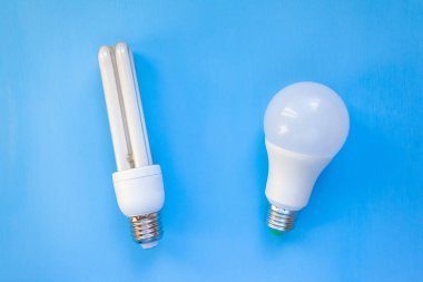 Lider ve enerji tasarruflu ampuller mavi bir arkaplanda yan yana uzanır.