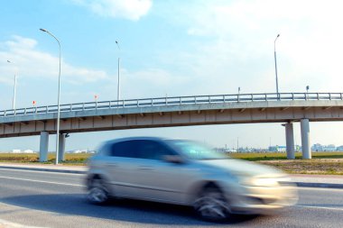 fast moving blurred car on the background of a trestle bridge clipart