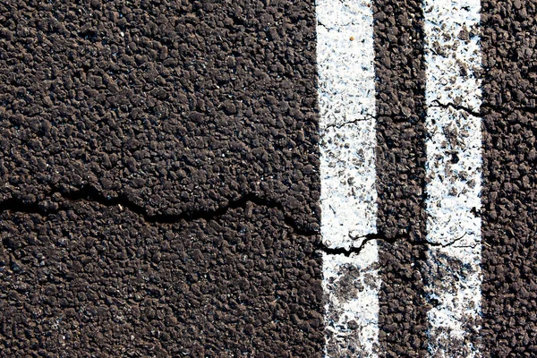 Riss Auf Dem Neuen Asphalt Mit Fahrbahnmarkierungen Draufsicht Hintergrund Textur — Stockfoto