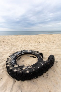 Sahilde eski bir araba lastiği.