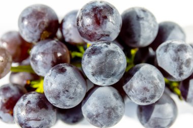 Parlak, olgun, mor üzüm meyvelerinin yakın çekimi.