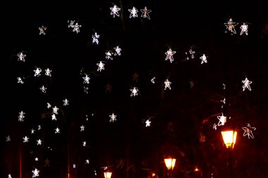 Gece kentinde ağaç dalları üzerine Noel süslemeleri