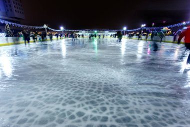 İnsanlar buz pateni pistinde uzun süre at sürerler.