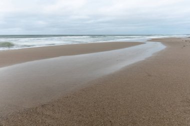 Soğuk Baltık Denizi kıyısındaki geniş kumlu sahil manzarası uzun süre açık havada bulutlu havada.