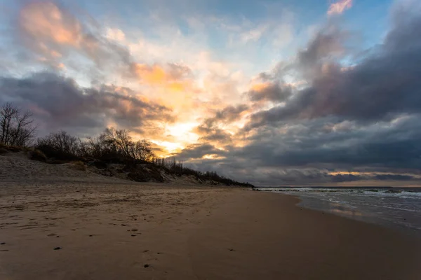 冬のバルト海の広いビーチ夕暮れ時に長い露出で日没の曇りの空の下 — ストック写真