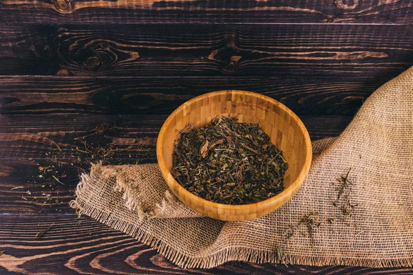 dried grass in a wooden Cup on a dark wooden background