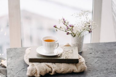 Çay, battaniye, örgü penceresinde çiçekler