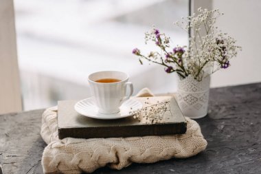 Çay, battaniye, örgü penceresinde çiçekler