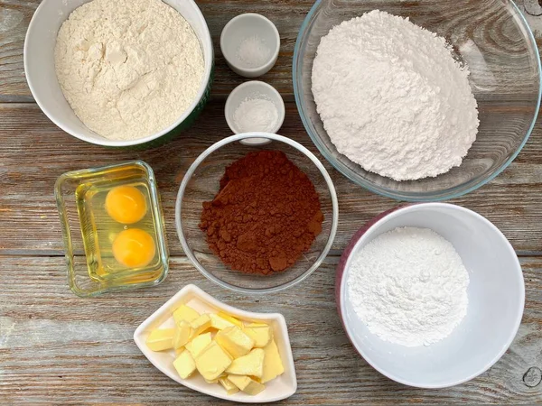 Продуктовый набор для выпечки шоколадного печенья на деревянном фоне, готовый к рецепту шаг за шагом . — стоковое фото
