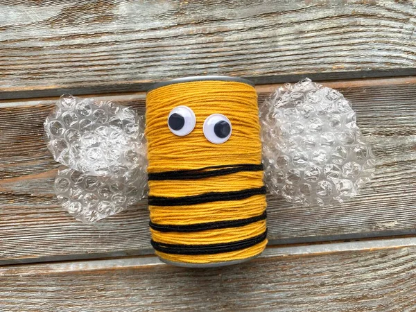 Ett bi gjort av garn och en plåtburk utan mustasch, barnens kreativitet. — Stockfoto