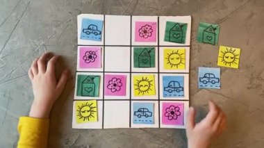 Çocukların elleri çocuk kartlarıyla sudoku oynuyor.,