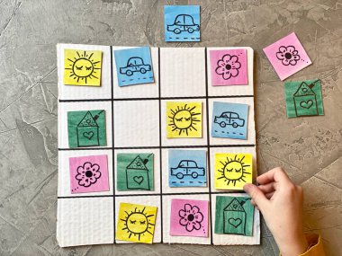 Bir çocuk, parlak kartları yeniden düzenlemek için Sudoku ile mantıklı bir oyun oynar..