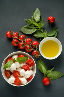 Mozzarella peyniri, fesleğen ve domates kiraz gri bir adam