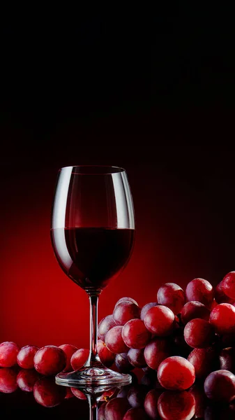 Glas Rotwein Mit Trauben Auf Schwarzem Spiegelhintergrund Mit Spiegelungen — Stockfoto