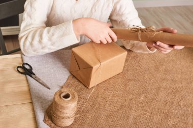Woman packaging box. Kraft wrapping paper and natural twine. Recycling material. Happy holiday present, surprise. Gifts for boxing day. Delivery service, shipping. Handwork art craft. Celebration. Foc clipart