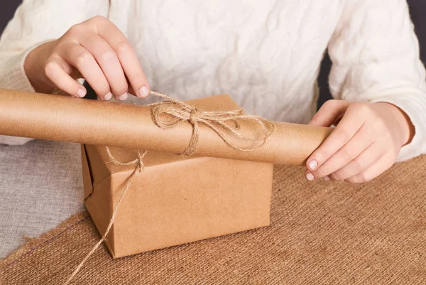 Woman packaging box. Kraft wrapping paper and natural twine. Recycling material. Happy holiday present, surprise. Gifts for boxing day. Delivery service, shipping. Handwork art craft. Celebration. Foc — Stock Photo, Image