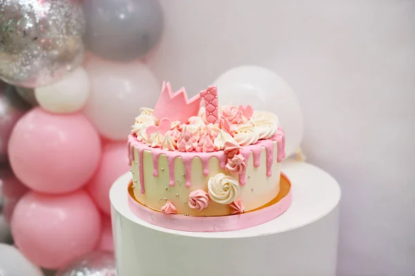 近景生日蛋糕1年 甜粉色蛋糕 装饰女孩 一个公主金王冠和1号白色背景与文字的地方 有氦气球的一周岁生日 — 图库照片